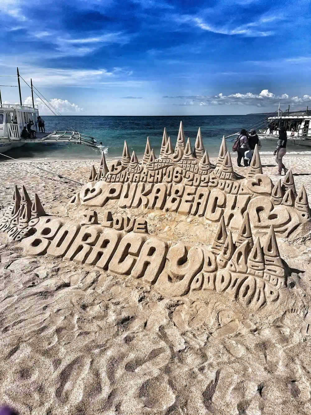 an elaborate sand sculpture spelling out Puka Beach Boracay