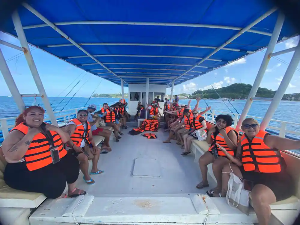 the full boat of guests in orange life vests under the blue canopy