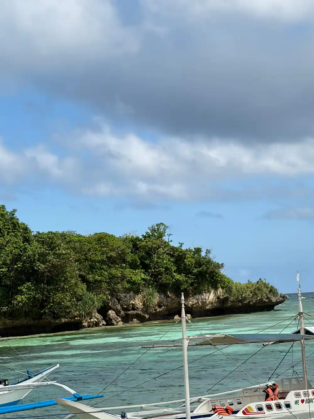 a green headland dropping to the sea with the outrigger arm in frame