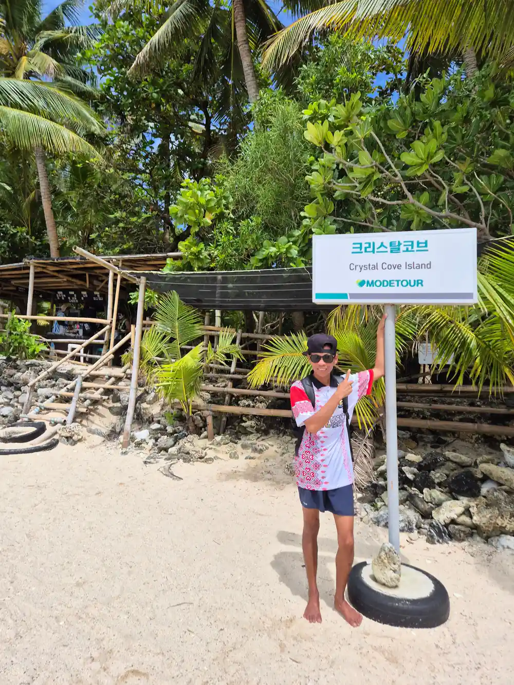 a guide holding a Crystal Cove Island placard on the beach