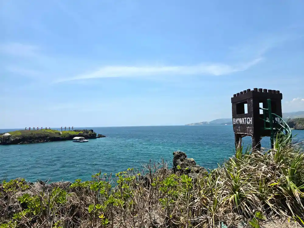 a lookout tower on a headland above the sea and the island beyond