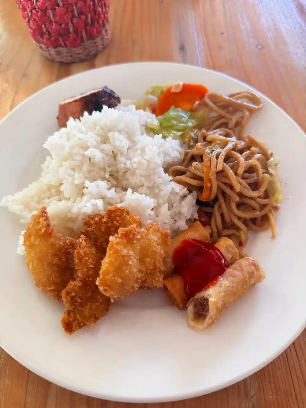 a plate of rice, noodles and fried fish from the buffet