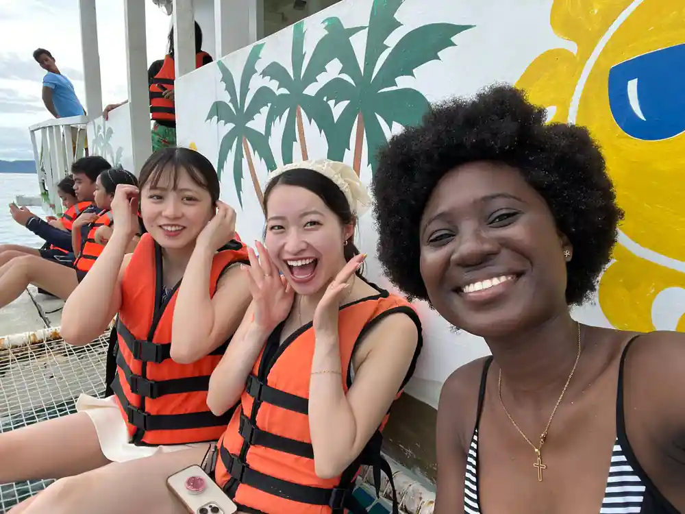 three guests in life vests laughing together on the boat