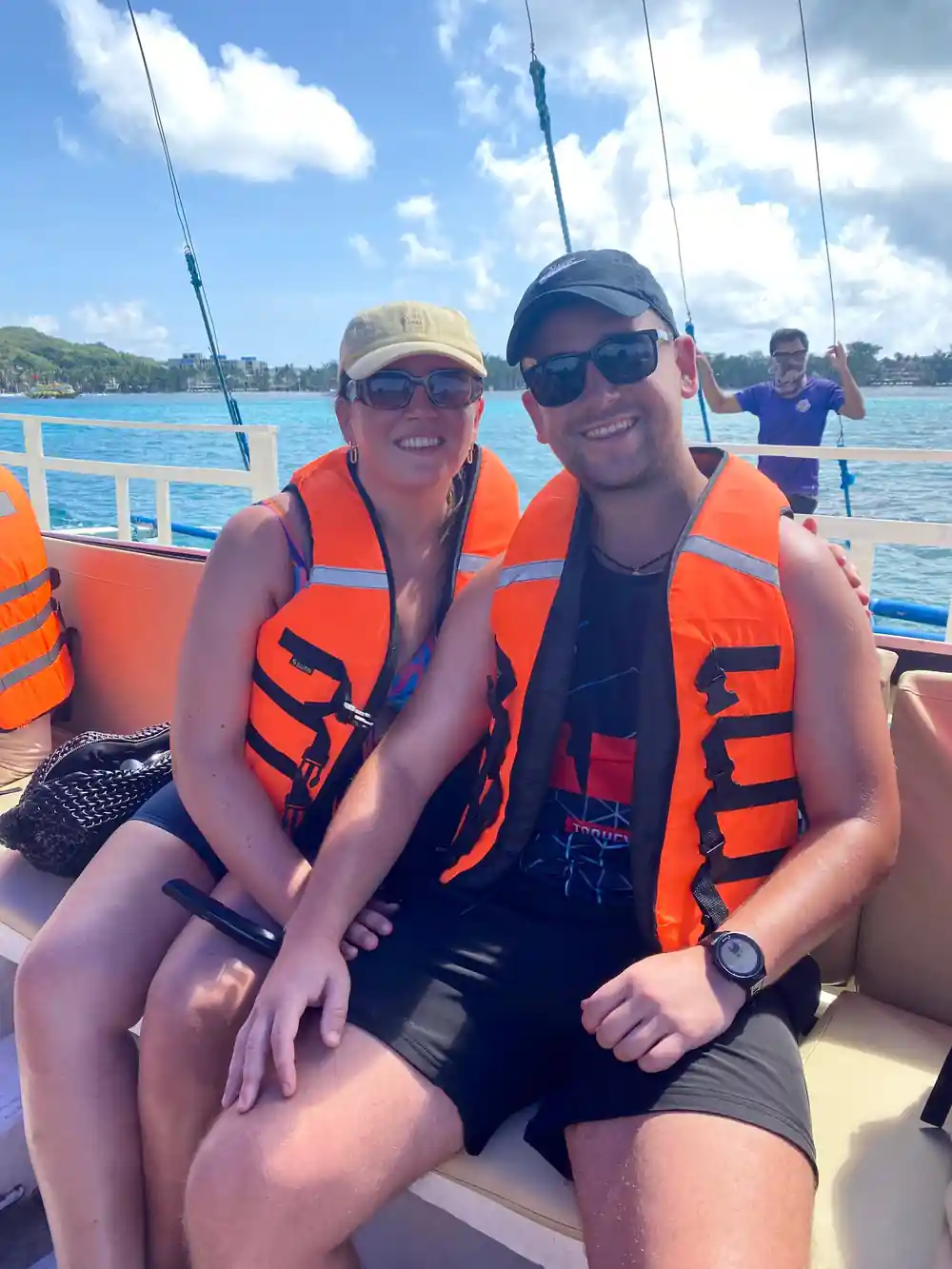 two guests in life vests seated together on the boat